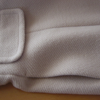 アイボリー色のコートの画像