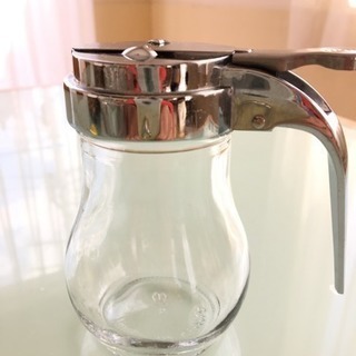 カフェにある ガラスとステンレスのシュガー&ハチミツ容器