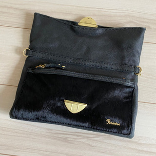 クラッチバッグと黒トップスのセットの画像