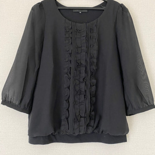 クラッチバッグと黒トップスのセットの画像