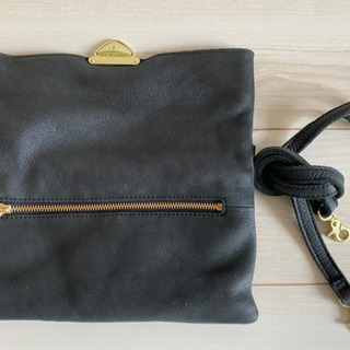 クラッチバッグと黒トップスのセットの画像