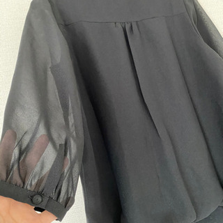 クラッチバッグと黒トップスのセットの画像