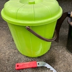 草刈り鎌と植木鉢の画像