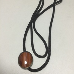 オレンジの飾りのついた紐ネクタイの画像