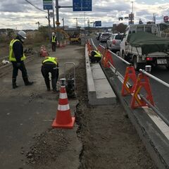 女川原子力発電所、ねじ切り機械の手元補助作業の画像