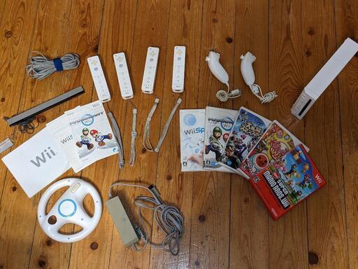 Wii本体とゲームソフト5つとリモコン4本とヌンチャクとハンドル