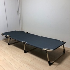 折りたたみベッド、折りたたみの椅子、ガラステーブル、壁掛けのアート