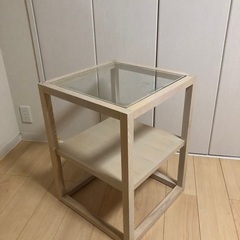 折りたたみベッド、折りたたみの椅子、ガラステーブル、壁掛けのアートの画像