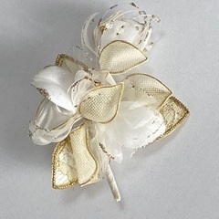 白色と金色の花束のような形のコサージュ