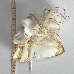 白色と金色の花束のような形のコサージュの画像