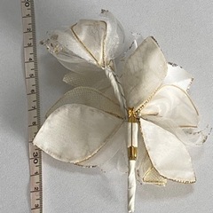 白色と金色の花束のような形のコサージュの画像