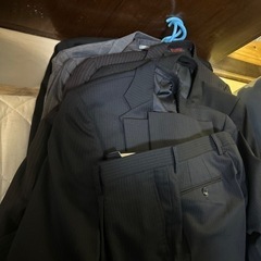 スーツ7着　そのほか衣装ケース一箱分の衣料作業服など　女性服一袋の画像