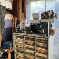 大量の電工作部品、オシロスコープ、デジタルマルチメーターなどの計測機器、抵抗器、トランジスタ、コンデンサの画像