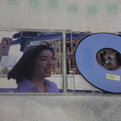 ♣　Smile 岡本真夜 　かすかな哀しさを内包したヴォーカルによる明るく元気なポップンロールこそ、ガールポップの典型だったと思い出させる岡本真夜です。夢を見るお年頃の女のコのラヴ・ソングが、けなげに男のコを励ます時代なのですね。岡本真夜が写した写真集付き。の画像