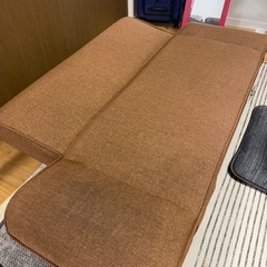 ブラウン色のフラットになるソファの画像