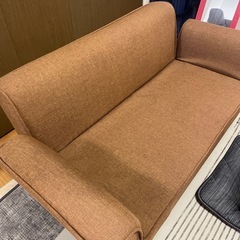 ブラウン色のフラットになるソファの画像