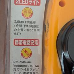 昔の携帯電話の充電器と手回しライトの画像