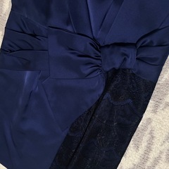 ネイビーのラップスタイルドレス、リボンとレースのディテールが特徴。 の画像