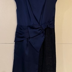 ネイビーのラップスタイルドレス、リボンとレースのディテールが特徴。 の画像