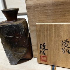 陶器製の茶色と黒の徳利、作家名の印付き。 の画像