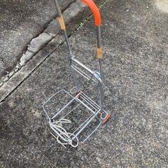 荷物を乗せて運ぶ押しぐるまの画像