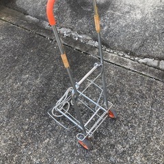 荷物を乗せて運ぶ押しぐるまの画像