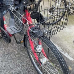 赤い自転車チャイルドシート付き、前部バスケットとリアキャリア付き。の画像
