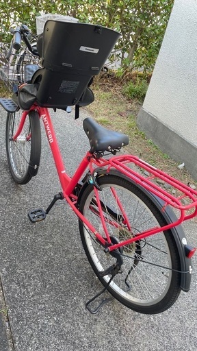 赤い自転車チャイルドシート付き、前部バスケットとリアキャリア付き。 赤い自転車チャイルドシート付き、前部バスケットとリアキャリア付き。