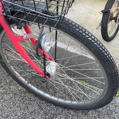 赤い自転車チャイルドシート付き、前部バスケットとリアキャリア付き。の画像