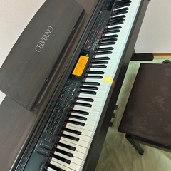 電子ピアノ、楽譜、椅子の画像