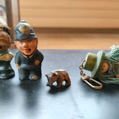 小さい人形と、小さい小さいクマの木彫りと、キーホルダー