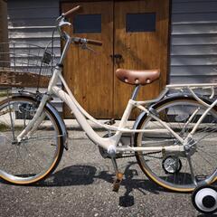 こども用自転車。クリーム色、補助輪付き