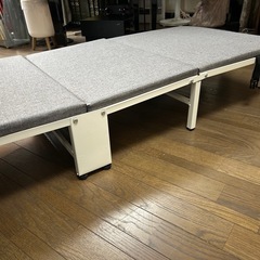 グレーの折り畳みベットの画像