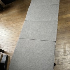 グレーの折り畳みベットの画像