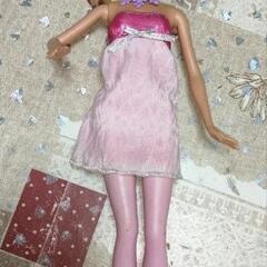 ピンクのタイツ、ブーツ、ネックレスをつけたバービー人形。Barbie 