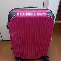 ハードシェルのピンクキャリーケース、内部にメッシュポケットとジッ...