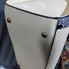 クリーム色と黒色のボストン型バッグの画像