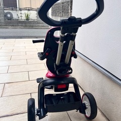 BMW製のピンクの三輪車、調整可能なハンドル付き。の画像