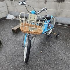 青色の幼児用自転車、かご付き、補助輪ありの画像