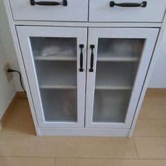 キャビネットとダイニングテーブルと椅子２つの画像