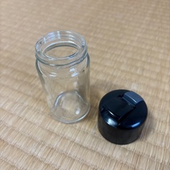 透明なガラスと黒いプラスチックの調味料入れの画像