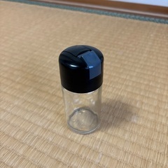透明なガラスと黒いプラスチックの調味料入れの画像