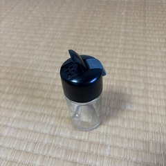 透明なガラスと黒いプラスチックの調味料入れの画像