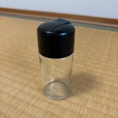 透明なガラスと黒いプラスチックの調味料入れ