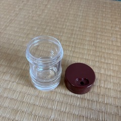 透明な調味料入れ、茶色のキャップの画像