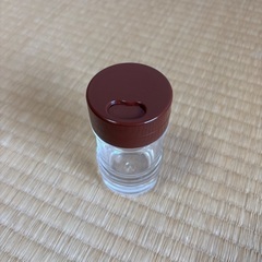 透明な調味料入れ、茶色のキャップの画像