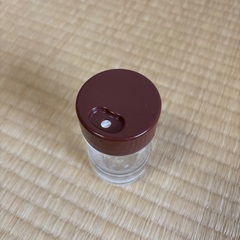 透明な調味料入れ、茶色のキャップの画像