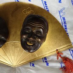 金色の扇に二面の笑顔の工芸品の画像