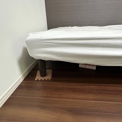 ニトリのマットレス付きシングルベッドとシーツの画像
