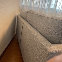 グレーのモダンソファとクッション2個の画像